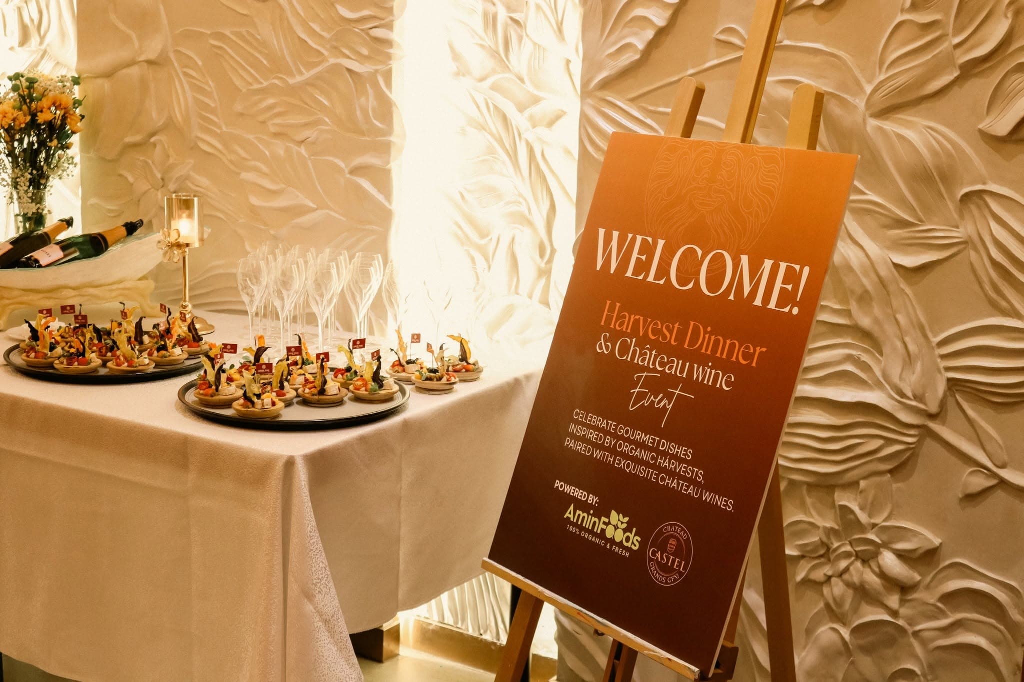 Harvest Dinner welcome sign beside canapés and prepared wine glasses.
