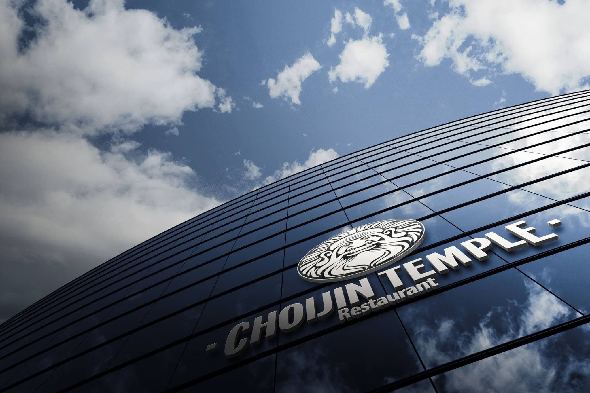 Choijin Temple sign on a reflective glass facade beneath a cloudy sky.